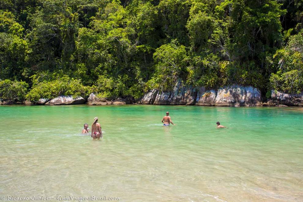 Imagem de uma família aproveitando o mar calmo da Praia do Puruba.